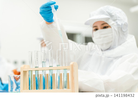 薬品工場,製薬会社で薬品開発をするクリーンスーツを着たスタッフ 薬品工場,製薬会社で薬品開発をするクリーンスーツを着たスタッフ 141198432