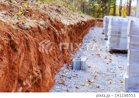 Construction site trench dug and stacked cement block located in wooded area Construction site trench dug and stacked cement block located in wooded area 141198553
