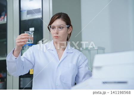 Laboratory technician analyzing chemical solution in a lab 141198568