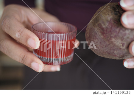 Holding beetroot and juice in hand for healthy drinks 141199123