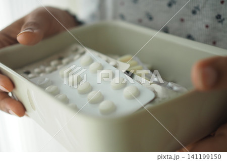 Person holding a box with various packs of medicine Person holding a box with various packs of medicine 141199150