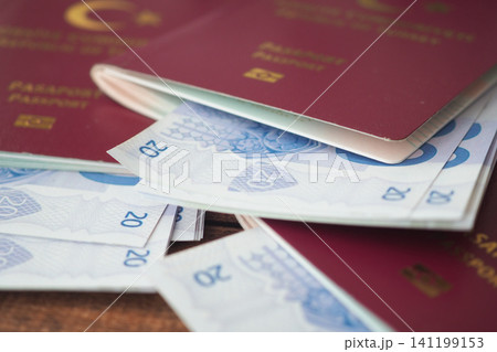 Passports and currency stacked on wooden table Passports and currency stacked on wooden table 141199153