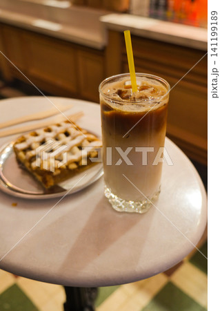 Iced coffee and dessert on a table at a cafe 141199189