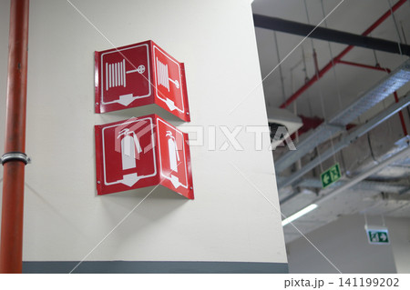 Signs indicate fire safety equipment in a building Signs indicate fire safety equipment in a building 141199202
