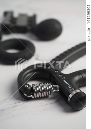 Hand grip strengthener on a flat surface with workout gear Hand grip strengthener on a flat surface with workout gear 141199301