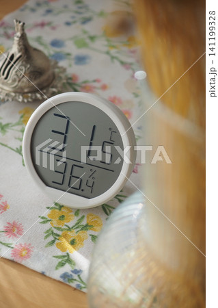 Digital thermometer shows temperature and humidity on table 141199328