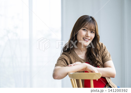 椅子に座る若い女性のポートレート 椅子に座る若い女性のポートレート 141200392