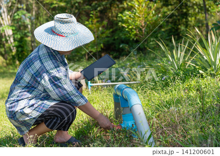 Farmer inspecting an irrigation pipeline digital tablet green field monitoring water supply supporting smart agriculture efficient farming crop management Farmer inspecting an irrigation pipeline digital tablet green field monitoring water supply supporting smart agriculture efficient farming crop management 141200601