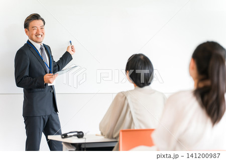 塾,セミナー,講習会でホワイトボードの前で講義する男性講師,教員,塾講師 塾,セミナー,講習会でホワイトボードの前で講義する男性講師,教員,塾講師 141200987