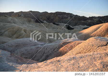 Majestic sierra nevada mountain towers above rugged desert landscape with dry rock formation and rolling sand hill conveying serene emotion under soft morning sunlight 141201337