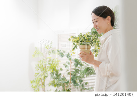 観葉植物を持つミドル女性 観葉植物を持つミドル女性 141201407