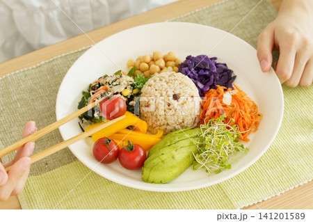 ワンプレートの健康的な食事をする若い日本人女性の手元のアップ ワンプレートの健康的な食事をする若い日本人女性の手元のアップ 141201589