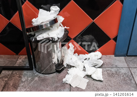 Waste paper napkins in a trash can in a public toilet 141201614