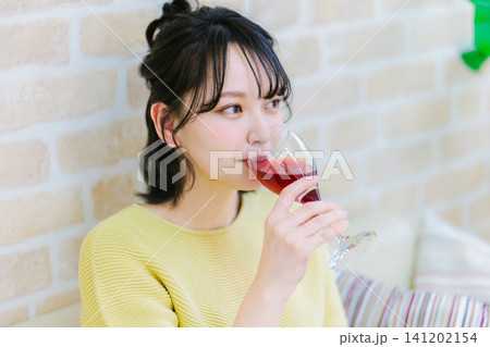 自宅で赤ワインを飲む若い女性 141202154