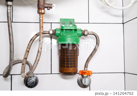 Household water filter installed on plumbing system with visible sediment cartridge Household water filter installed on plumbing system with visible sediment cartridge 141204702