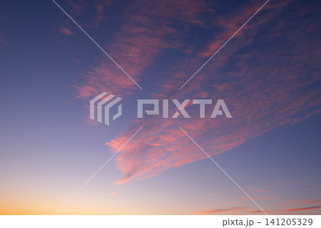 Beautiful serene pink cloud formation floating in vast twilight blue sky during sunset and sunrise over majestic nature in utah usa bringing profoundly peaceful feeling to any observer everyday 141205329