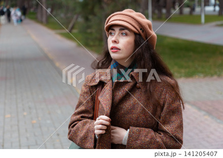 Portrait of beautiful woman strolls through quiet streets on a fall day, reflecting on her emotions during a solo city walk. 141205407