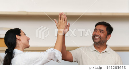 Diverse colleagues giving high five for success and teamwork Diverse colleagues giving high five for success and teamwork 141205658