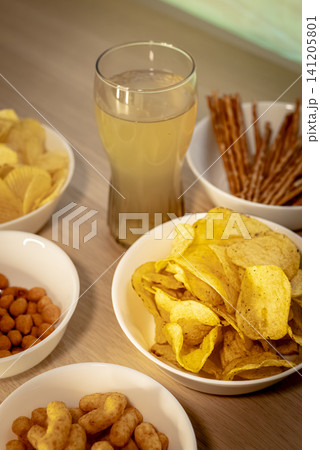 Assorted snacks and a beverage arranged on a tabletop, illustrating a game day snack table prepared for football fans. Assorted snacks and a beverage arranged on a tabletop, illustrating a game day snack table prepared for football fans. 141205801