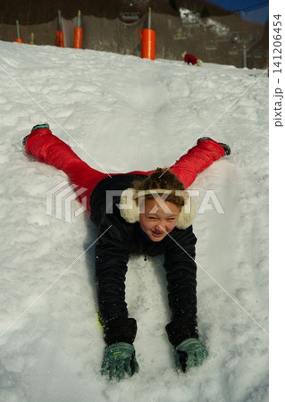Child Enjoying Snow Sledding with Joyful Expression Child Enjoying Snow Sledding with Joyful Expression 141206454