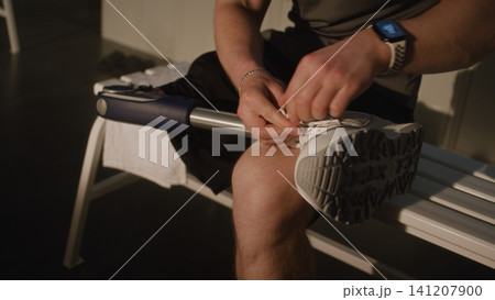 Young Man Hands Tying Shoelaces on White Sneaker Worn on Bionic Leg Prosthesis Young Man Hands Tying Shoelaces on White Sneaker Worn on Bionic Leg Prosthesis 141207900