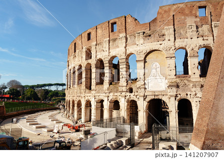 Group of workers repairs the exterior of the Colosseum in Rome in the morning light 141207907