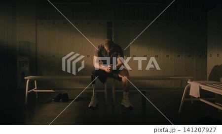 Resilient Man with Physical Disability Reflecting in Locker Room 141207927
