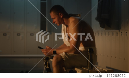 Resilient Man with Leg Prosthesis Checking Phone in Sunlit Dressing Room Resilient Man with Leg Prosthesis Checking Phone in Sunlit Dressing Room 141208032