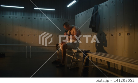 Confident Young Athlete with Prosthetic Leg Walks Through Bright, Sunlit Locker Room 141208053