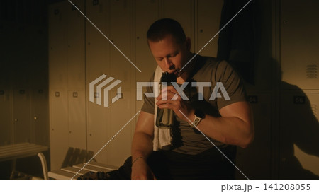 Athlete with Prosthetic Leg Resting in Sunlit Locker Room After Workout Athlete with Prosthetic Leg Resting in Sunlit Locker Room After Workout 141208055