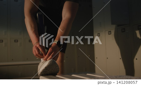 Man with Bionic Leg Prosthesis Adjusting Sports Shoes for Training 141208057