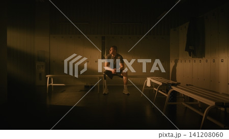 Amputee Athlete Finding Inner Strength and Focus in Sunlit Locker Room Amputee Athlete Finding Inner Strength and Focus in Sunlit Locker Room 141208060