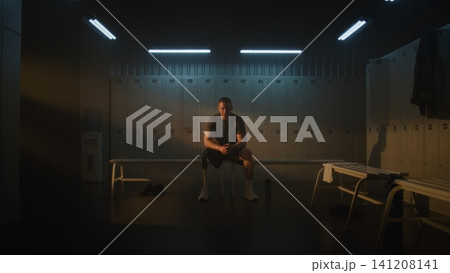 Determined Male Athlete with Prosthetic Leg Resting in Locker Room After Exercise Determined Male Athlete with Prosthetic Leg Resting in Locker Room After Exercise 141208141