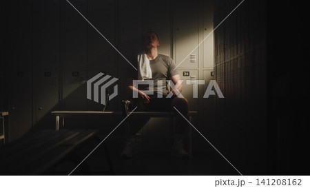 Professional Athlete with Leg Prosthesis Resting in Dressing Room 141208162