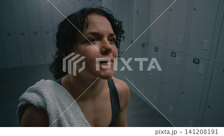 Exhausted but Determined Woman Resting in Dark Locker Room Exhausted but Determined Woman Resting in Dark Locker Room 141208191