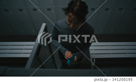 Athletic Woman Preparing for Workout in Gym Locker Room 141208195