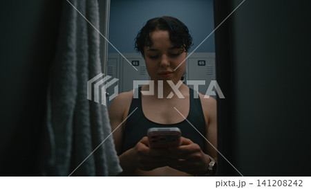 Young Female Athlete Using Smartphone After Workout Young Female Athlete Using Smartphone After Workout 141208242