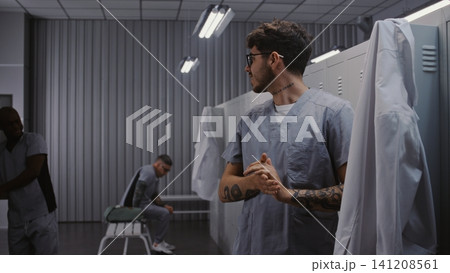 Medical Staff Interacting and Changing Uniforms in Modern Hospital Staff Dressing Room Medical Staff Interacting and Changing Uniforms in Modern Hospital Staff Dressing Room 141208561