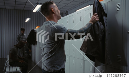 Diverse Factory Workers Laughing and Talking While Changing in Modern Industrial Locker Room Diverse Factory Workers Laughing and Talking While Changing in Modern Industrial Locker Room 141208567