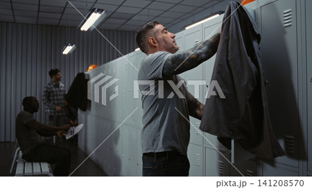 Diverse Factory Workers Laughing and Talking While Changing in Modern Industrial Locker Room Diverse Factory Workers Laughing and Talking While Changing in Modern Industrial Locker Room 141208570