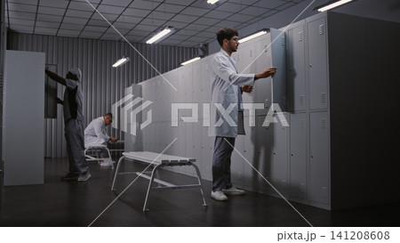 Diverse Group of Doctors Changing Clothes in Hospital Locker Room After Long Medical Shift Diverse Group of Doctors Changing Clothes in Hospital Locker Room After Long Medical Shift 141208608
