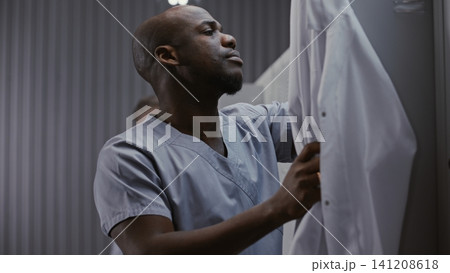 Tired Surgeon Rubbing Face in Medical Locker Room Tired Surgeon Rubbing Face in Medical Locker Room 141208618