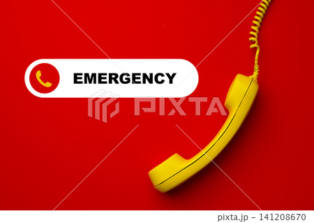 Emergency service phone on red background with yellow receiver for urgent calls and assistance Emergency service phone on red background with yellow receiver for urgent calls and assistance 141208670