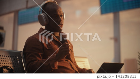African American Businessman Putting on Headphones for Video Call at Airport African American Businessman Putting on Headphones for Video Call at Airport 141208813
