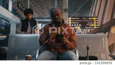 Traveler Scanning Digital Boarding Pass and Drinking Coffee Traveler Scanning Digital Boarding Pass and Drinking Coffee 141208859