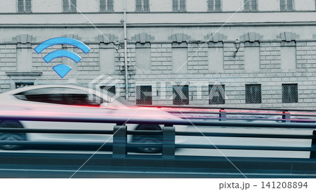 Car moves past building with wireless signal displayed above on busy street 141208894
