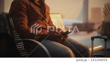 Male Texting on Smartphone in Airport Waiting Area Male Texting on Smartphone in Airport Waiting Area 141208959