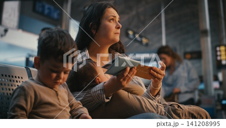 Authentic Moment of Mother Breastfeeding Baby at Airport Departure Gate Authentic Moment of Mother Breastfeeding Baby at Airport Departure Gate 141208995