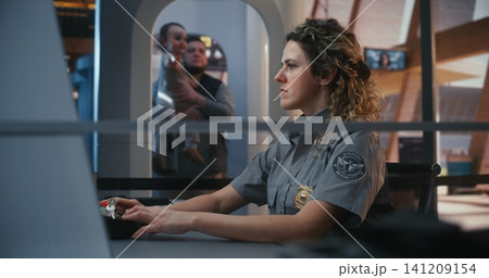 Uniformed Officer Managing Luggage Scanning System at Airport Entrance Uniformed Officer Managing Luggage Scanning System at Airport Entrance 141209154