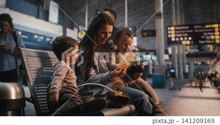 Mother with Two Toddlers Waiting in Airport Terminal Hall Before Flight Mother with Two Toddlers Waiting in Airport Terminal Hall Before Flight 141209169